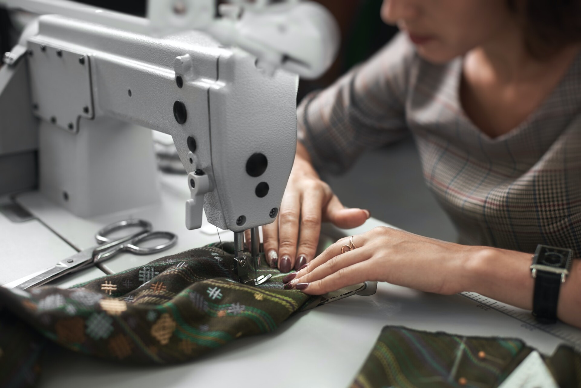 seamstress-working-on-modern-electrical-sewing-machine-making-exclusive-garments-in-fashion-studio-1-1.jpg